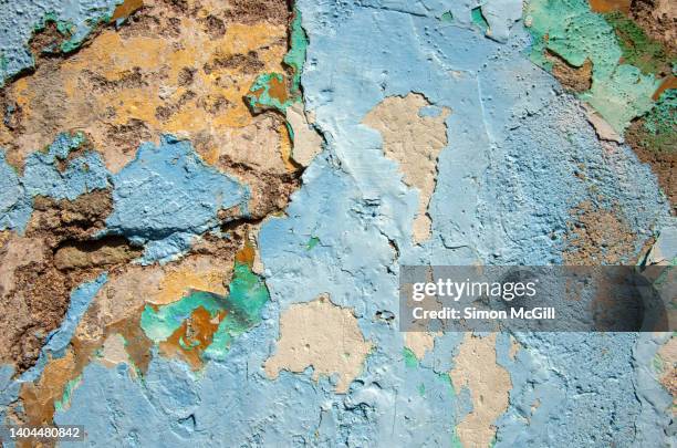 layers of different colored paints peeling off a crumbling stucco wall - mottled stock pictures, royalty-free photos & images