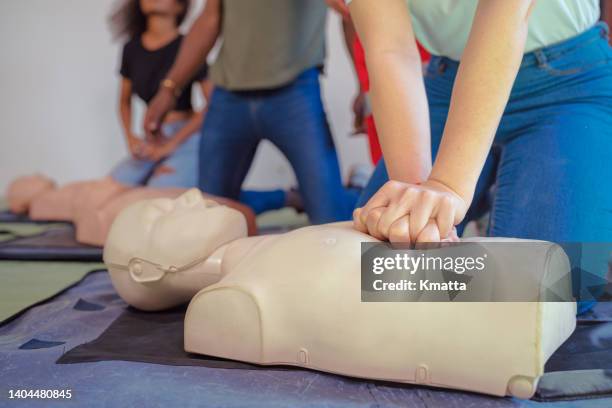 hands of a trainee doing chest compression during defibrillator cpr training. - training course 個照片及圖片檔