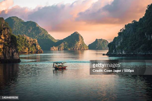 scenic view of boat in river against sky during sunset,vietnam - vietnã - fotografias e filmes do acervo