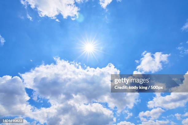 low angle view of sun shining in blue sky - 素材 stock pictures, royalty-free photos & images