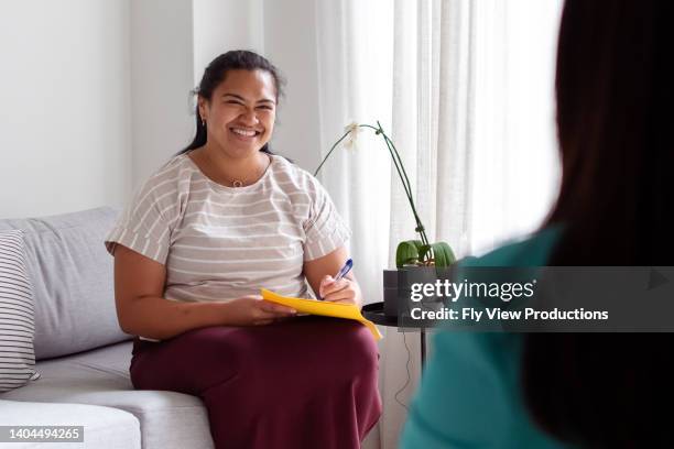 encouraging therapist talking with female patient - house call stockfoto's en -beelden