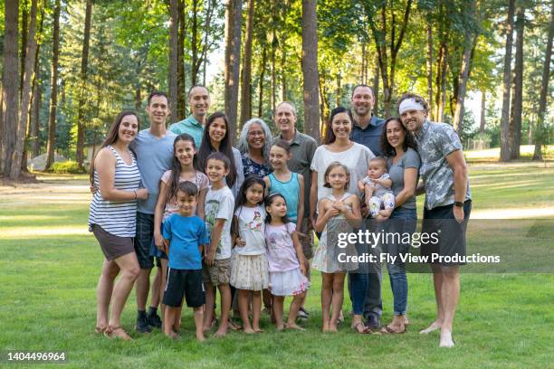 multi-generation family celebrating reunion together outdoors - cousins stock pictures, royalty-free photos & images