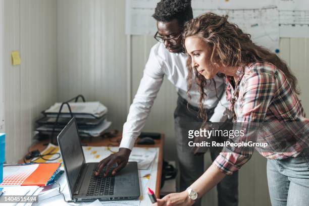 man and woman are looking at the blueprints at the office and making a new project. - civil engineer stock pictures, royalty-free photos & images