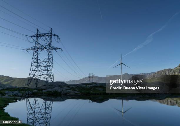 high-voltage power lines pylon and wind turbine - electricity pylon stock-fotos und bilder