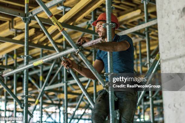 builder putting up scaffolding - scaffolding stock pictures, royalty-free photos & images
