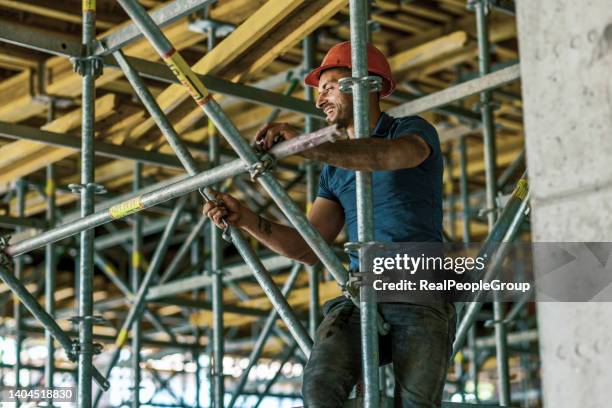 builder putting up scaffolding - scaffolding industrial stock pictures, royalty-free photos & images