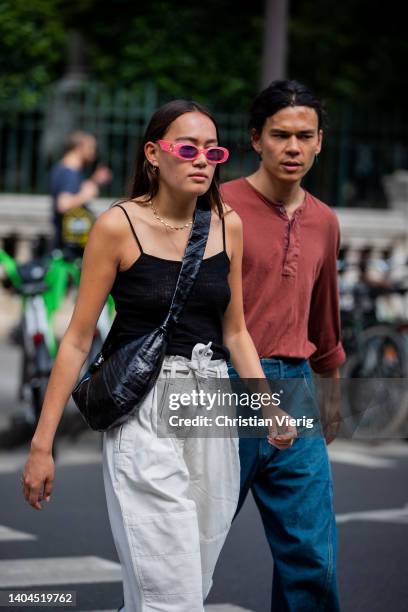 Guest is seen wearing grey high waist pants, black top, bag outside Lemaire during Paris Fashion Week - Menswear Spring/Summer 2023 on June 22, 2022...