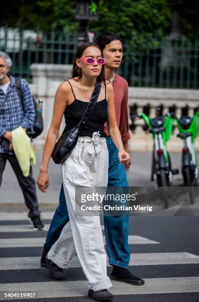 Guest is seen wearing grey high waist pants, black top, bag outside Lemaire during Paris Fashion Week - Menswear Spring/Summer 2023 on June 22, 2022...