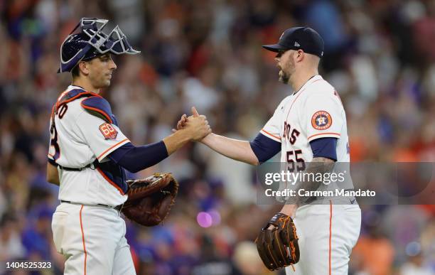 Jason Castro of the Houston Astros high fives Ryan Pressly after defeating the New York Mets 5-3 at Minute Maid Park on June 22, 2022 in Houston,...