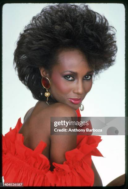 Portrait of Somali-born American fashion model Iman, dressed in red ruffled, strapless top, as she poses against a white background, New York, New...