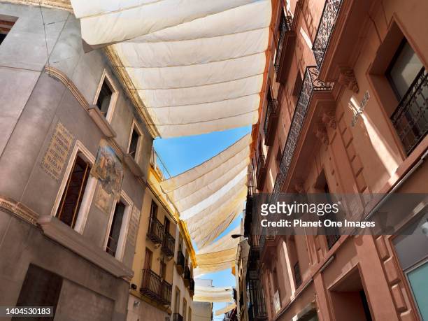 Seville, Andalucia, Spain - 31 May 2016; no people in view. Cloth awnings protect shoppers and pedestrians from the fierce summer sun in Calle...