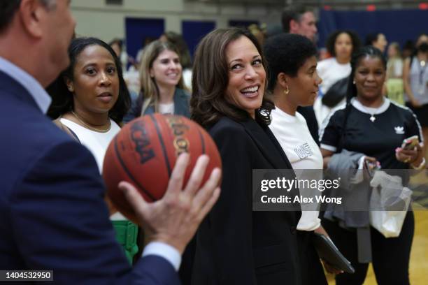 Vice President Kamala Harris looks on as her husband Doug Emhoff holds a basketball during a Title IX 50th Anniversary Field Day event at American...