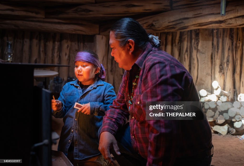 Dad teaching his son to lit a traditional stove