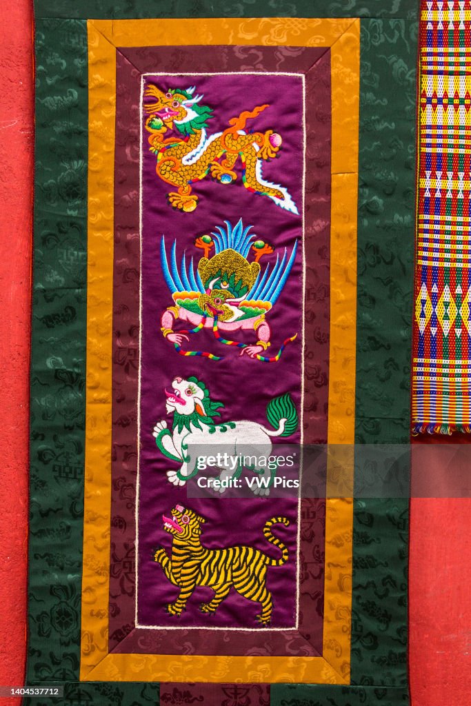A silk embroidered wall hanging depicting animals of Buddhist mythology
