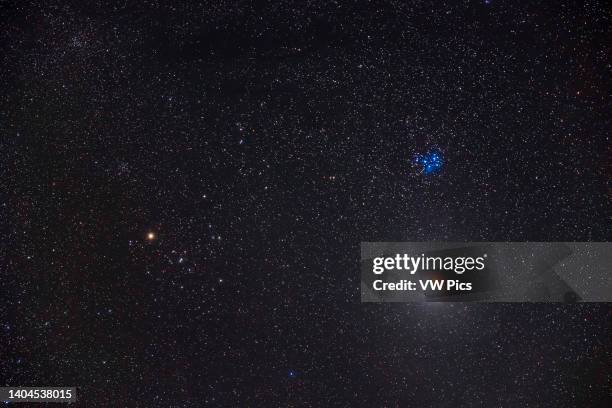 The partial eclipse of the Moon of November 19 with the Moon below the Pleiades star cluster, M45, and near the Hyades cluster and Aldebaran at left,...