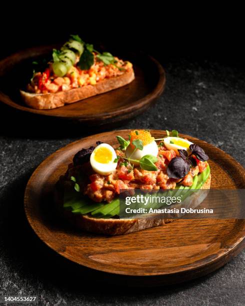 various of original bruschettas on wooden plate. - avocado toast stock pictures, royalty-free photos & images