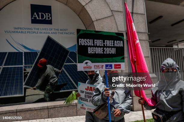 Climate activists dressed in PPE suits protest outside the Asian Development Bank headquarters in Mandaluyong City. The group called on ADB—currently...