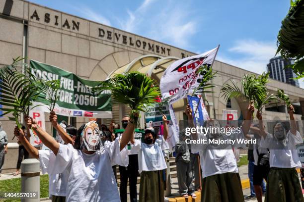 Climate activists dressed in PPE suits protest outside the Asian Development Bank headquarters in Mandaluyong City. The group called on ADB—currently...