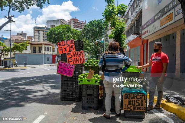 Street vendor sells avocados of different types in dollars. Although the official currency in Venezuela is still the Bolivar, the most widely used...