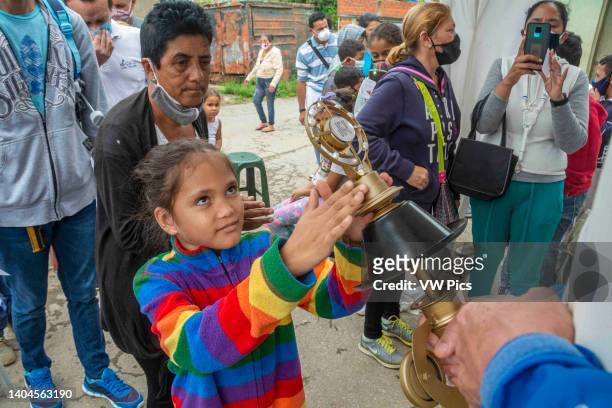 Girl touches with her hands the relic of Blessed Jose Gregorio Hernandez, for his blessing. Relic of Blessed Jose Gregorio Hernandez. Caracas,...
