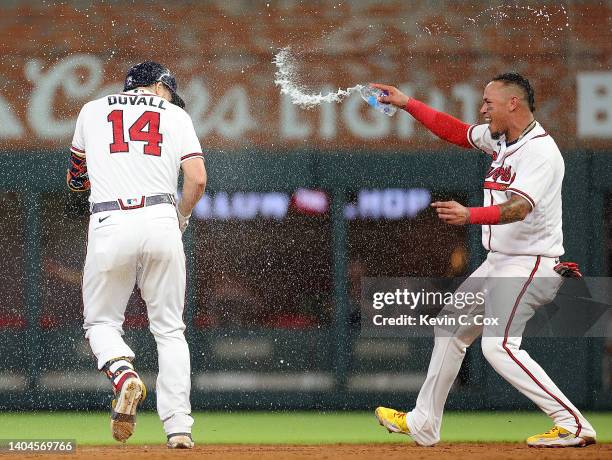 Adam Duvall of the Atlanta Braves celebrates with Orlando Arcia after hitting a walk-off single to score the winning run by William Contreras in the...