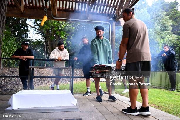Ardie Savea and Caleb Clarke help lay food in a hangi during their visit to the Waitangi Treaty grounds on June 23, 2022 in Waitangi, New Zealand.