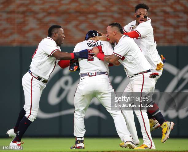 Adam Duvall of the Atlanta Braves celebrates with Guillermo Heredia, Orlando Arcia and Ronald Acuna Jr. #13 after hitting a walk-off single to score...