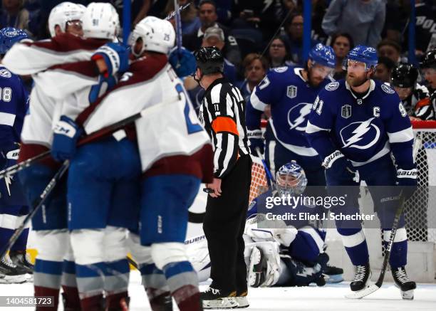 Steven Stamkos and goaltender Andrei Vasilevskiy of the Tampa Bay Lightning react as the Colorado Avalanche celebrate the overtime goal by Nazem...