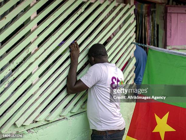 Cameroonian fan looks out through the gaps of a makeshift Cameroonian restaurant in a working class area of Libreville on January 14, 2022 during the...