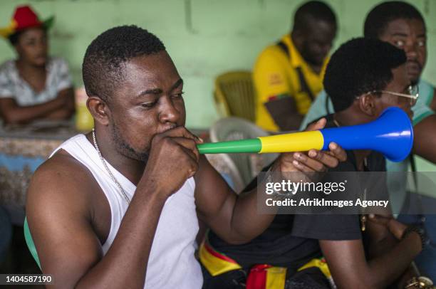 Cameroonian fan blows a vuvuzela in the colours of Gabon at a Cameroonian makeshift restaurant in a popular neighbourhood in Libreville during the...