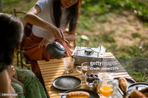 cheerful and happy multi-generation asian family enjoy their drinks during camper van road trip. - asian family camping stock pictures, royalty-free photos & images