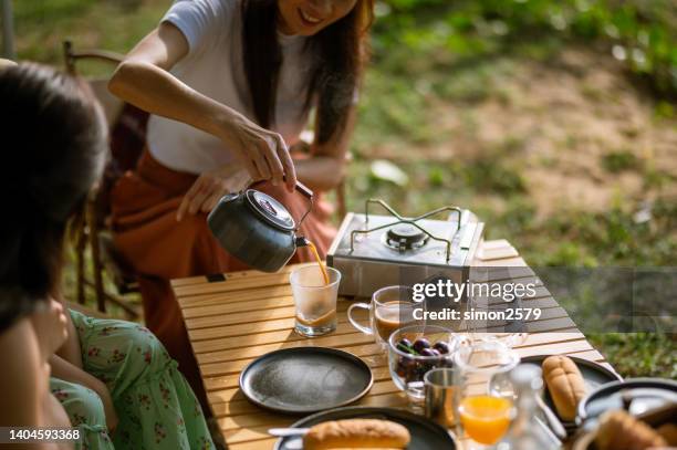 cheerful and happy multi-generation asian family enjoy their drinks during camper van road trip. - camper van imagens e fotografias de stock