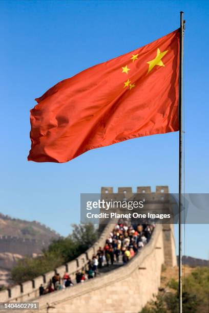 Red flag flies over the crowded Great Wall of China at Badaling.