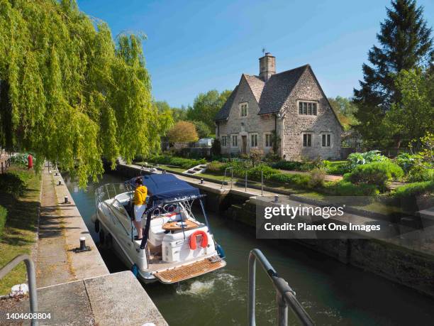 Locks on the River Thames at Iffley, summer morning, boat passing. Iffley, Oxfordshire, England, May 2019.