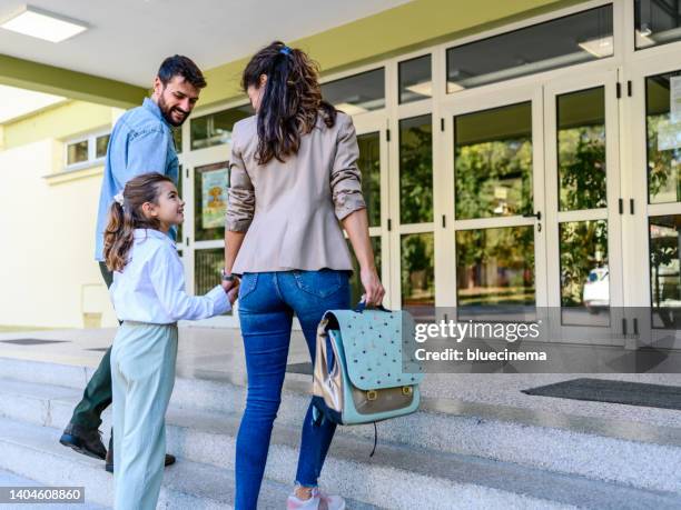 mother and father taking their daughter to school - school building entrance stock pictures, royalty-free photos & images