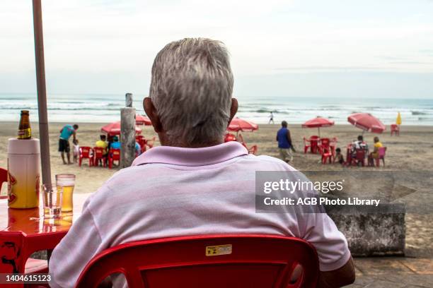 Homem toma cerveja em um quiosque a beira-mar na Praia Grande, litoral sul de Sao Paulo. – FOTO: ALF RIBEIRO Man takes beer, kiosk, waterfront, ,...