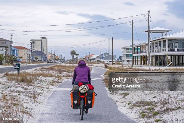 Touring cyclist cycling along bicycle path/cycle track through the town Navarre in winter, Santa Rosa County, Florida, United States/USA.