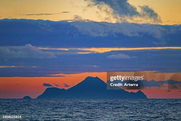 Saba, Dutch island and one of three special municipalities of the Netherlands in the Caribbean Sea, showing active volcano Mount Scenery at sunset.