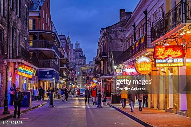 Bars and pizza restaurants at night in Bourbon Street, French Quarter/Vieux Carré in the city New Orleans, Louisiana, United States/USA.