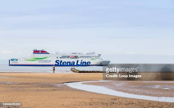 The Stena Embla ferry exits the River Mersey passing an Iron Man on Crosby beach.