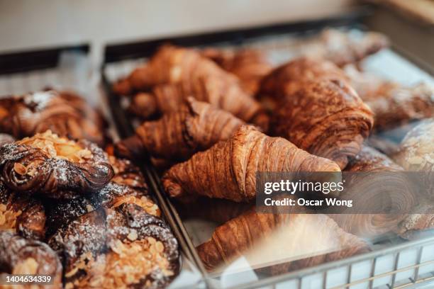 close-up of fresh french baked pastry in the display cabinet in a cafe. - baked goods stockfoto's en -beelden