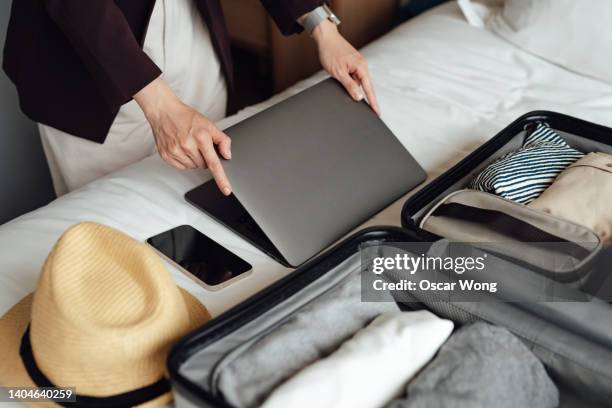 close-up of businesswoman packing luggage in hotel room - businesswoman hotel stock pictures, royalty-free photos & images