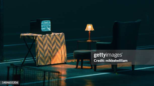 watching television in a chair outside on a parking lot - forsaken film stockfoto's en -beelden