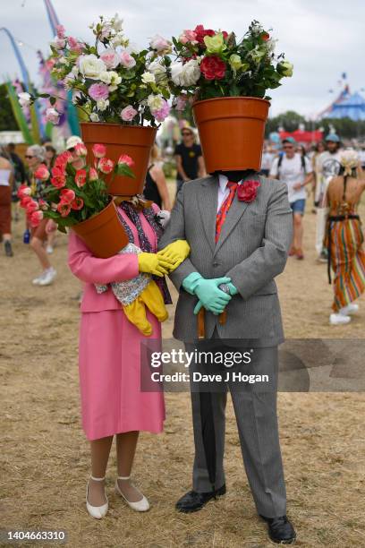 Couple dressed as flower pots walk around the site during day two of Glastonbury Festival at Worthy Farm, Pilton on June 23, 2022 in Glastonbury,...