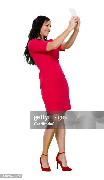caucasian female photography standing in front of white background wearing dress and using smart phone - cut out dress stock pictures, royalty-free photos & images