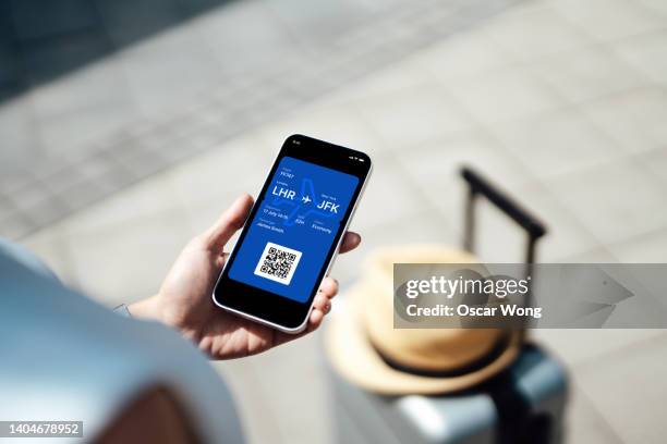 close-up of female hand holding smart phone with boarding pass - airplane ticket 個照片及圖片檔