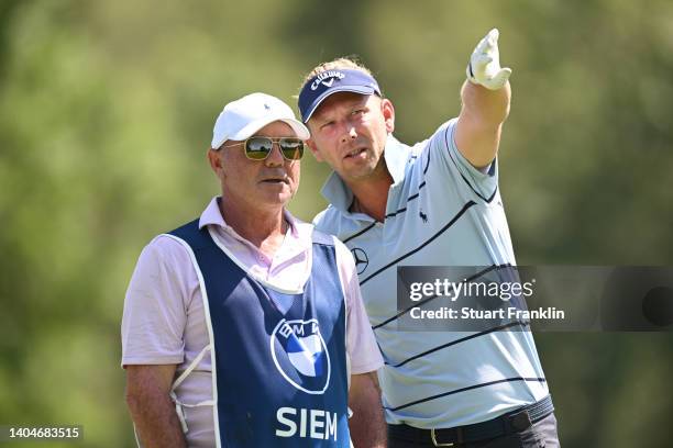 Marcel Siem of Germany consults his caddie, Kyle Roadley before teeing off on the 11th hole during the first round of the BMW International Open at...