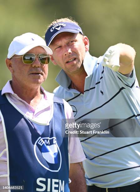 Marcel Siem of Germany consults his caddie, Kyle Roadley before teeing off on the 11th hole during the first round of the BMW International Open at...