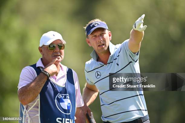 Marcel Siem of Germany consults his caddie, Kyle Roadley before teeing off on the 11th hole during the first round of the BMW International Open at...