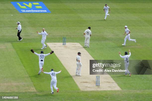 Jack Leach and England celebrate the wicket of Henry Nicholls of New Zealand after rebounding off the bat of Daryl Mitchell at the non strikers end...